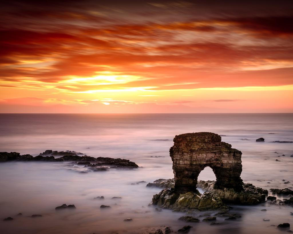 日落期间海洋上的岩石风景照片高清壁纸