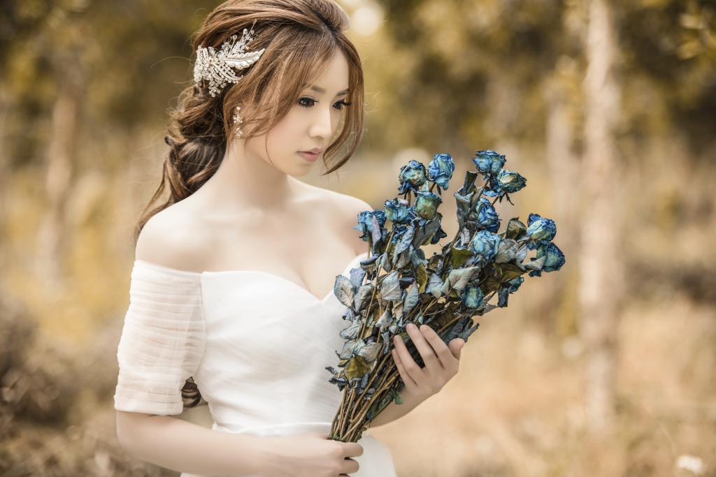 女人穿着白色的露肩礼服拿着蓝色和灰色的花纹高清壁纸