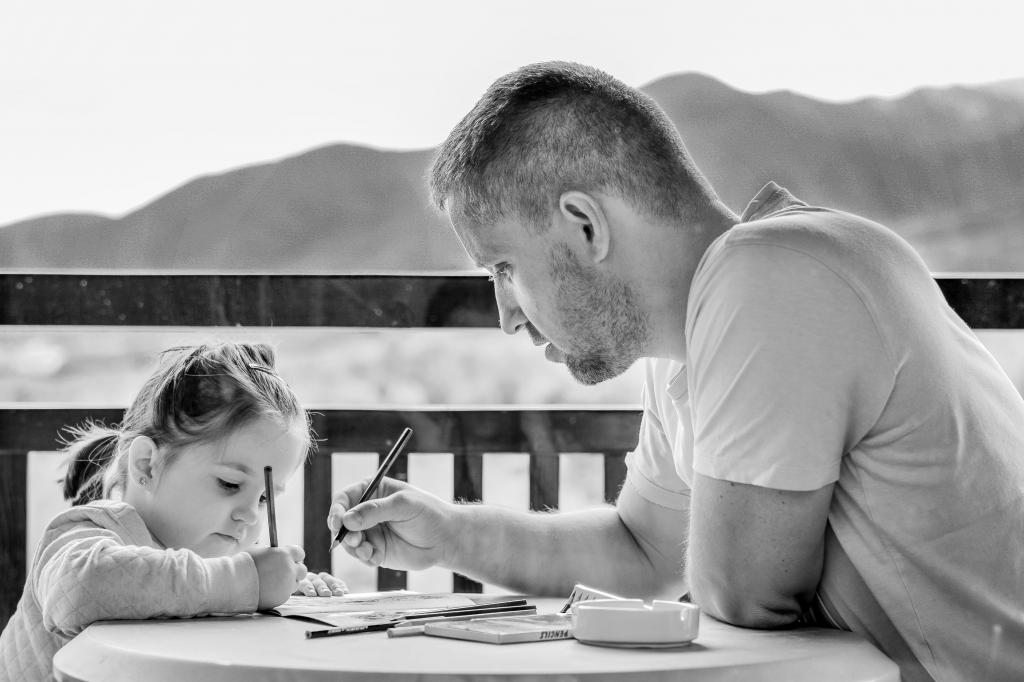 一个男人辅导他的女儿在一个桌子上的风景灰度高清壁纸