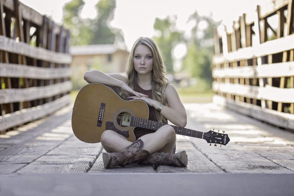 女人坐在桥上,用她的大腿上的吉他高清壁纸