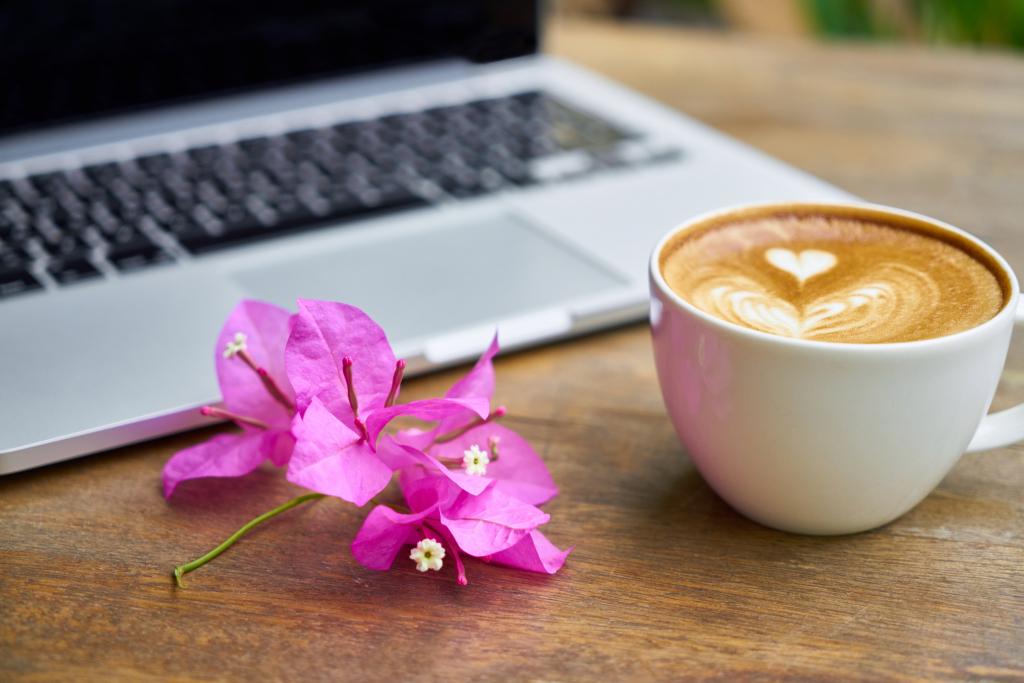 杯子的咖啡和便携式计算机在棕色的木桌子上的紫色豹纹的花高清壁纸