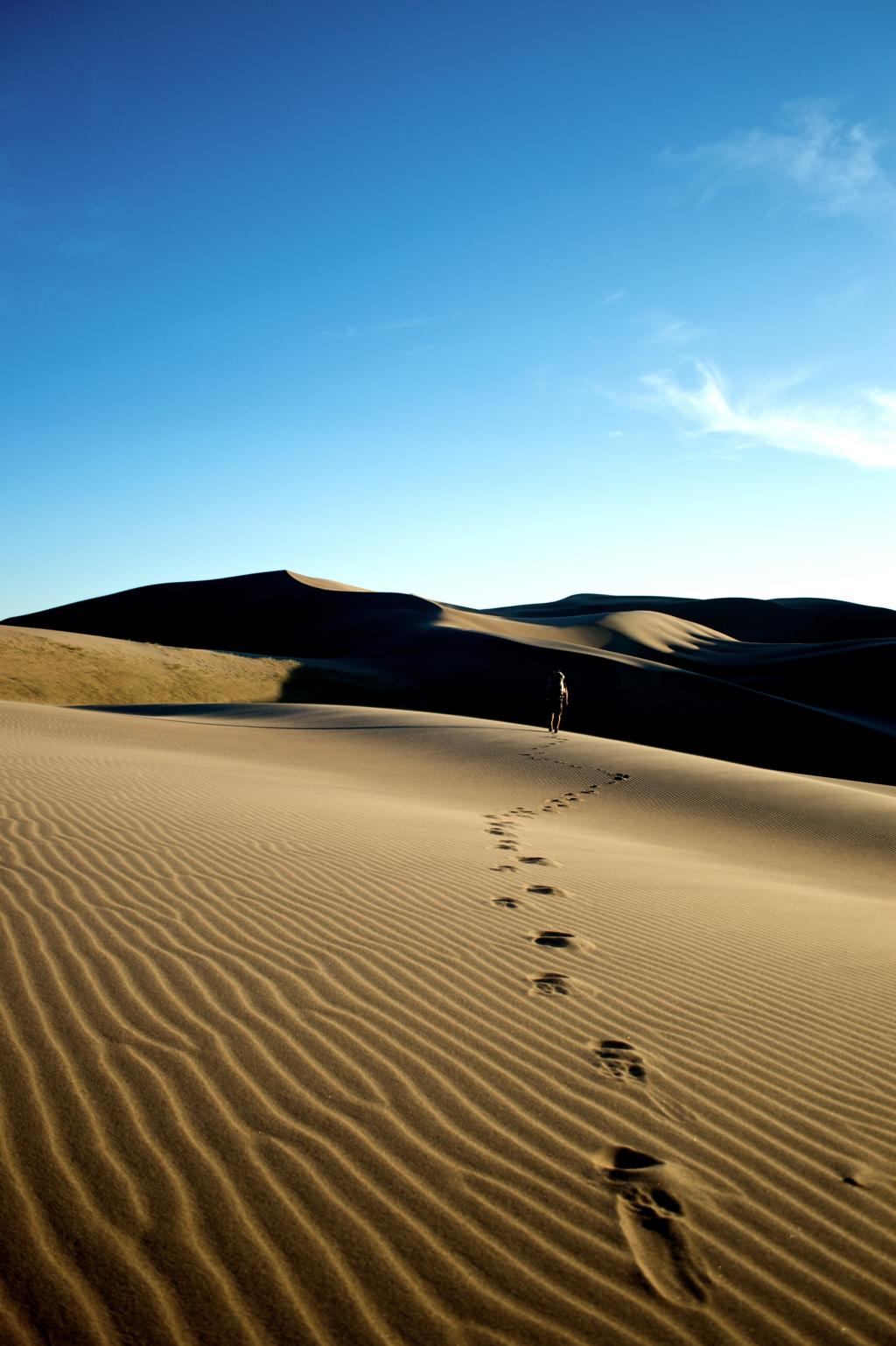 在沙漠上行走的人在白天高清壁纸留下脚步