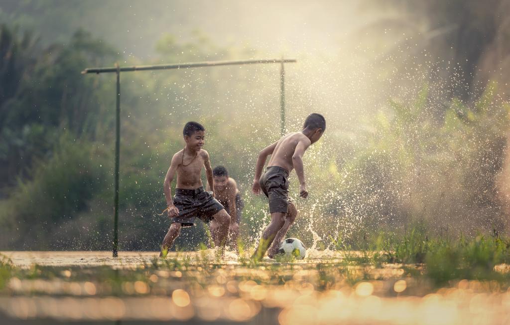 三个男孩在绿草场高清壁纸踢足球