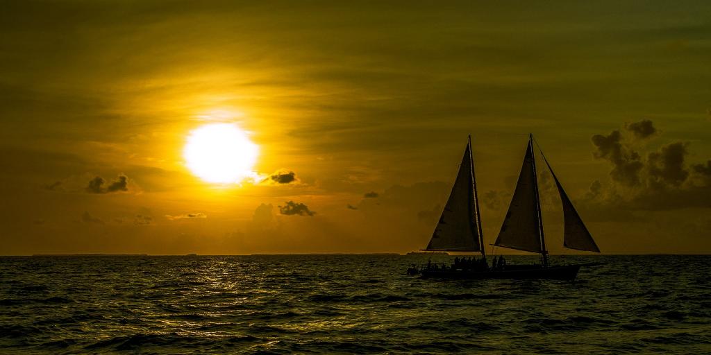 在与太阳背景水体中的两艘帆船的剪影照片高清壁纸