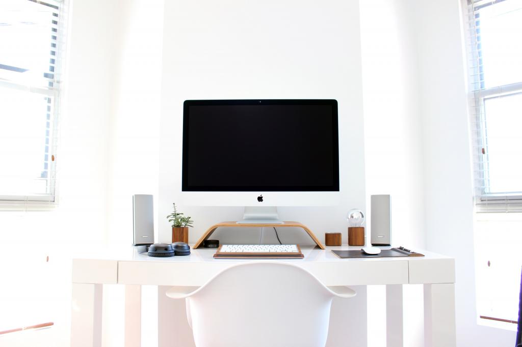 白色的木桌上的银iMac安装高清壁纸
