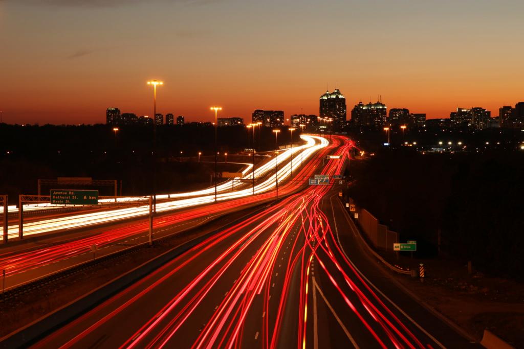 时间推移摄影的车辆在黄金时段,高速公路401,建筑物附近的道路上运行的车灯高清壁纸