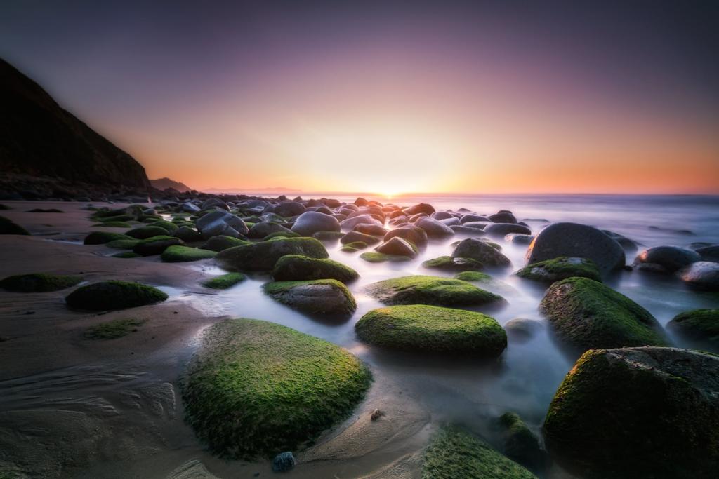 多岩石的海滩日落主题照片高清壁纸
