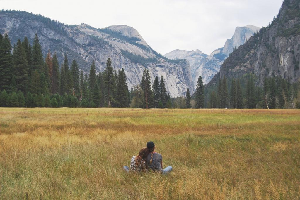 两个人坐在草地上,同时面对荒野高清壁纸