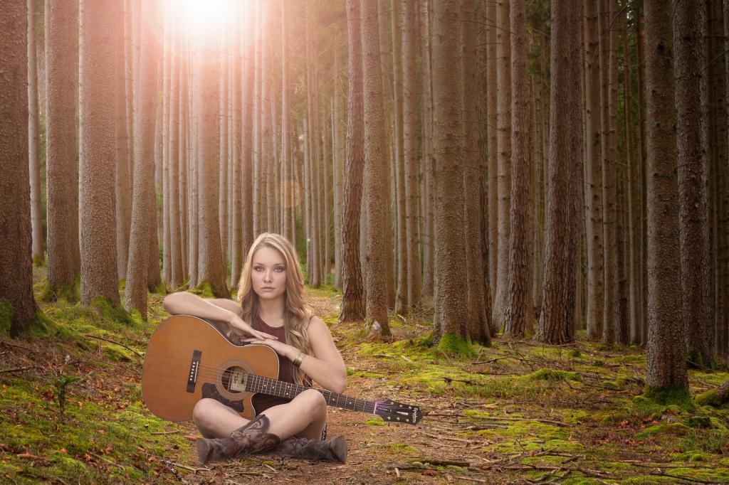女子持棕色古典吉他坐在森林高清壁纸的中间