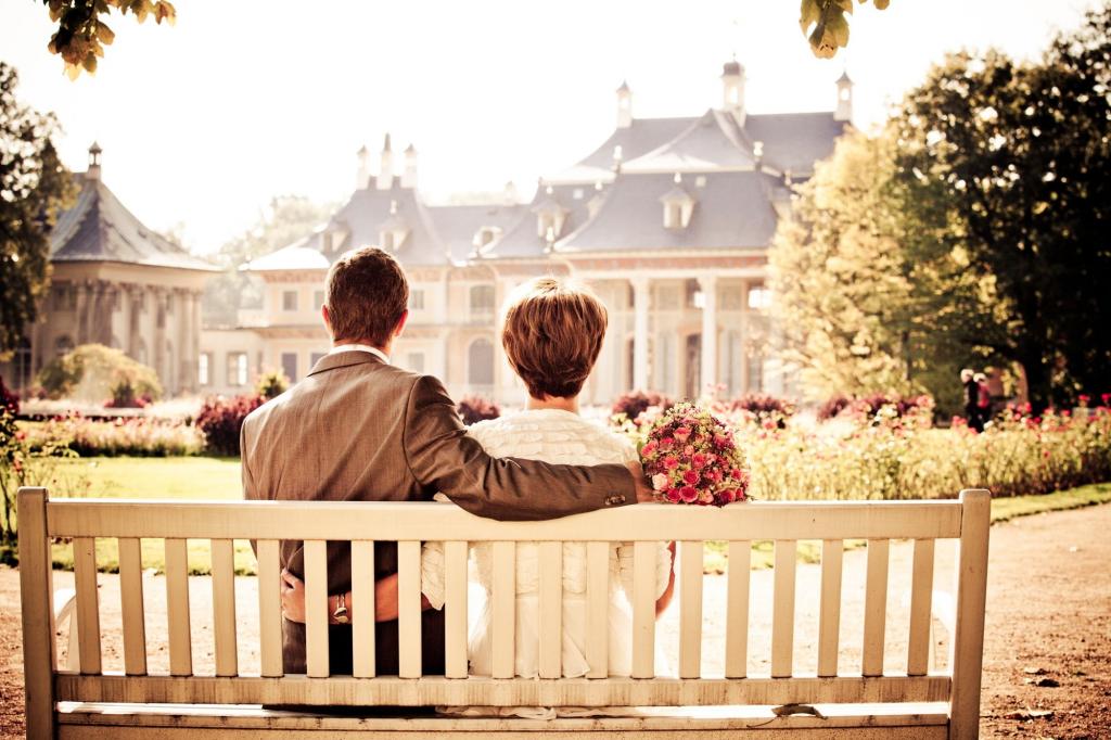 夫妇坐在长椅上面对房子在白天高清壁纸