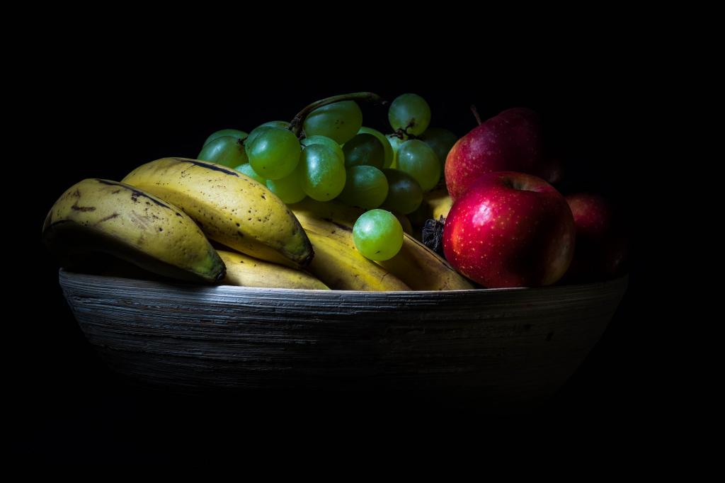 成熟的香蕉,绿色的葡萄和红色的苹果,在棕色的篮子里的照片高清壁纸