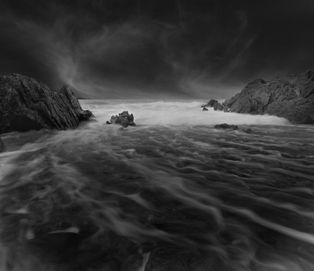 水体撞击沿海岩石的灰度摄影高清壁纸