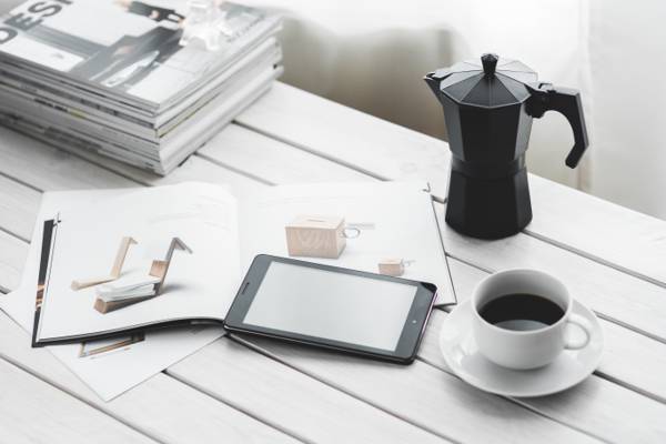 白色陶瓷茶杯旁边的黑色iPad和桌上的投手高清壁纸