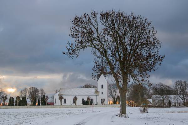 在多云的天空下教堂高清壁纸附近的雪地上光秃秃的树