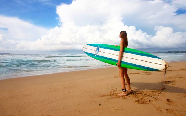 女人抱着绿色和白色冲浪板附近海域在蓝天下在一天时间高清壁纸