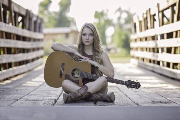 女人坐在桥上,用她的大腿上的吉他高清壁纸