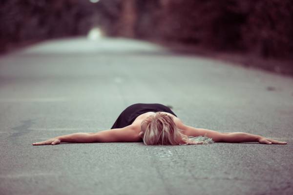 在白天高清壁纸躺在混凝土路上的黑裙子的女人