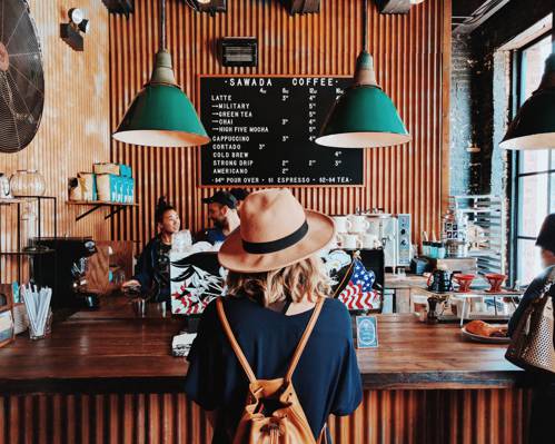 蓝色衬衫与咖啡厅柜台附近的棕色太阳帽子的女人高清壁纸