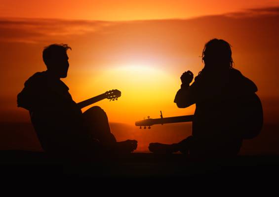 两个人在日落期间玩吉他的剪影高清壁纸