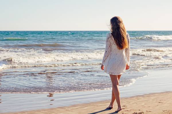 女人穿着白色的长袖的衣服,在金色的小时高清壁纸期间站在白色的沙滩上海边