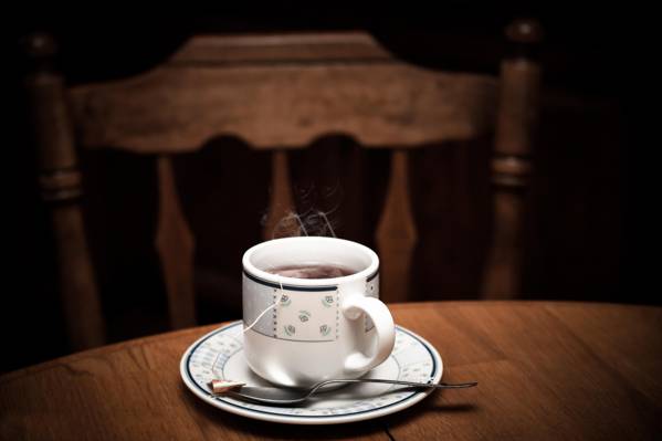 白色和黑色的花卉图案茶杯和碟子上充满了黑色的咖啡,棕色的木制桌子上附近的棕色木制的班尼特椅子高清壁纸