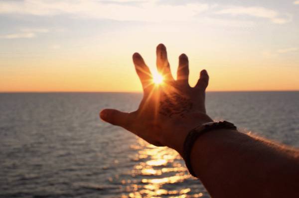 采取与太阳反射的手一张手照片的人HD墙纸
