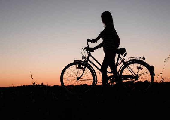 在日落时高清壁纸的女人控股自行车的剪影