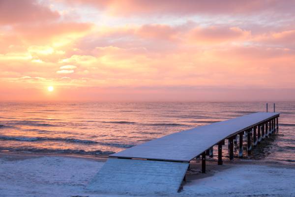 在日落期间的海滩旁边的白色木码头高清壁纸