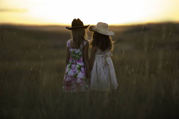 两个女孩戴着草帽站在绿草场高清壁纸的中间
