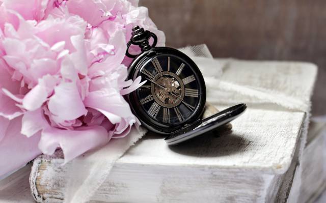 圆桌上的黑色怀表和粉红色的花桌上高清壁纸