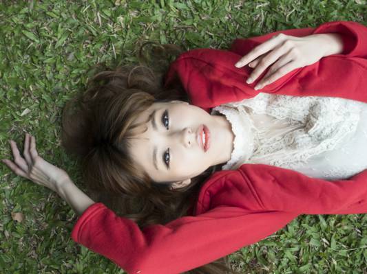 红色连帽衫躺在绿草场高清壁纸的女人