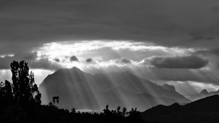太阳光线通过山附近的云高清壁纸