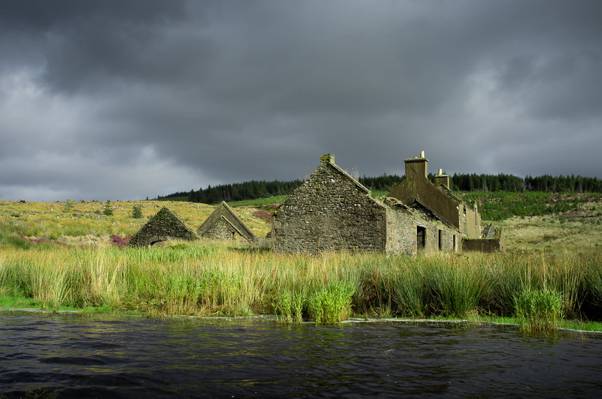 在乌云密布的天湖附近的绿草包围的房子高清壁纸