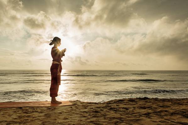 女人穿着棕色的水手脖子上的衬衫站在海边日落期间高清壁纸