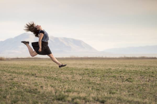 女人跳上绿草高清壁纸