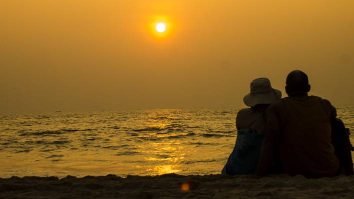 男人和女人在黄昏,果阿,印度高清壁纸坐在海边