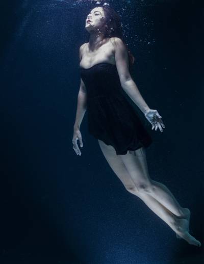 女人穿着黑色的露肩娃娃连衣裙在水下高清壁纸