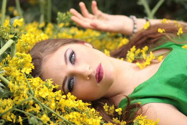妇女的绿色无袖礼服躺在黄色的花朵高清壁纸