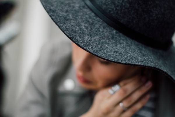 女人穿着灰色和黑色的帽子,抱着她的耳环高清壁纸