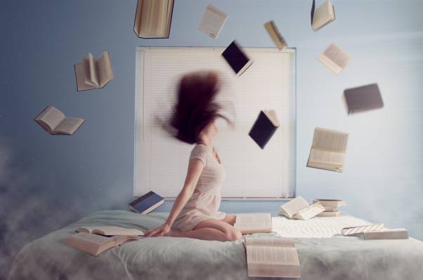 女子坐在床上,书籍飞高清壁纸
