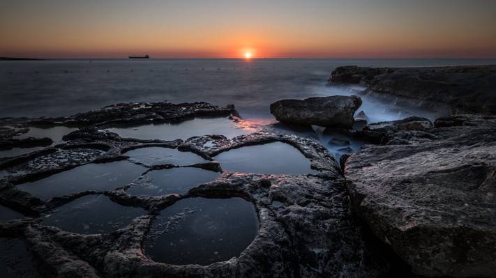 在金黄小时期间,marsaskala,马耳他HD墙纸期间,关闭黑岩层照片在海旁边的