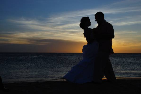 男人和女人在金色的小时高清壁纸在海边上跳舞的剪影