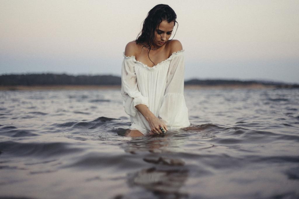 女人在白色长袖脱肩衬衫站在水的身体在白天高清壁纸