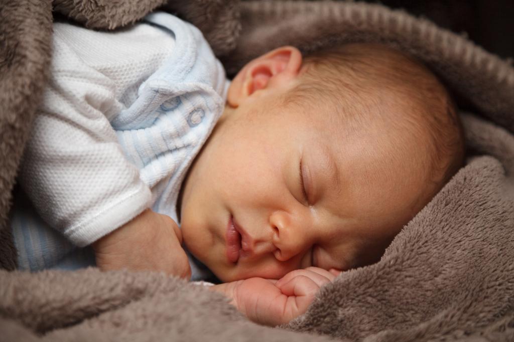 婴儿睡在褐色羊毛纺织上的白色睡眠套焦点照片高清壁纸