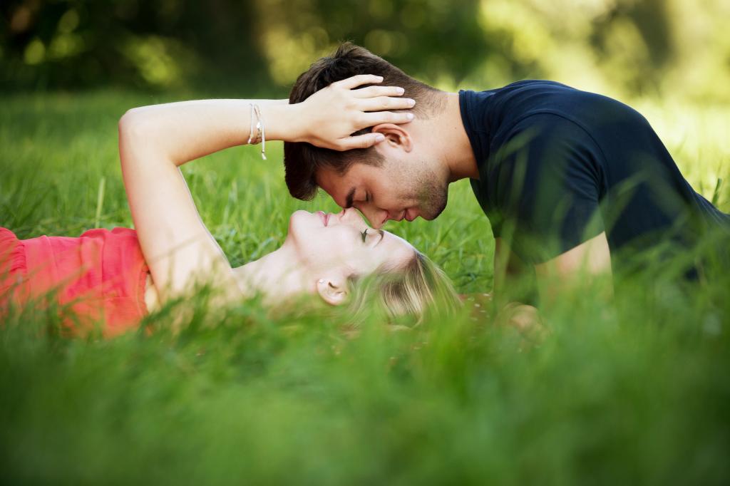 男人穿着蓝色衬衫在粉红色的女人躺在绿草场高清壁纸